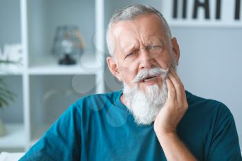 Senior man suffering from toothache at home�