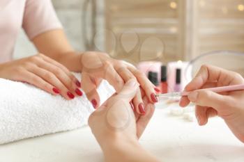 Woman getting professional manicure in beauty salon, closeup�