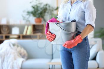 Woman with cleaning supplies in room, closeup�
