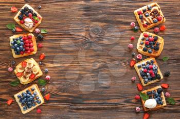 Tasty sweet waffles with berries on wooden table�
