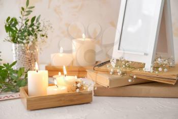 Beautiful burning candles and floral decor on table�