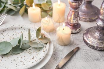 Beautiful table setting with burning candles and floral decor�