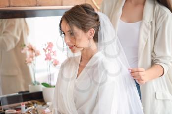 Professional hairdresser working with young bride at home 