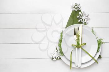 Beautiful table setting for Christmas dinner on white wooden background�