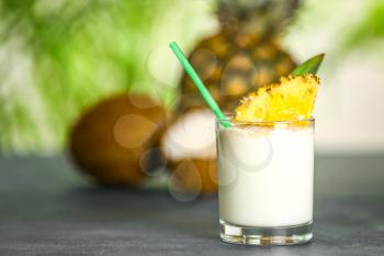 Glass of tasty Pina Colada cocktail on table�