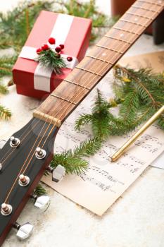 Guitar, note sheets, gift and Christmas decor on table�