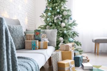 Interior of room with Christmas tree, sofa and many gifts�