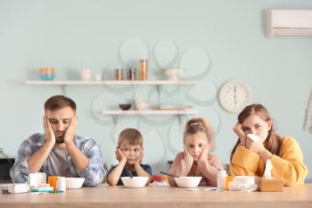 Family ill with flu sitting in kitchen�