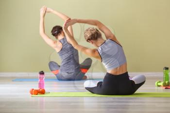 Young women practicing yoga in gym�