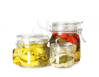 Jars with canned vegetables on white background�