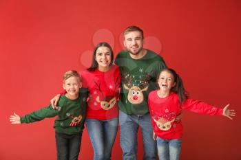 Happy family in Christmas sweaters on color background�