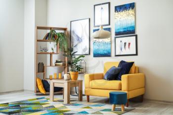 Stylish interior of living room with yellow armchair�