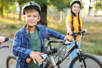 Cute children riding bicycles outdoors�