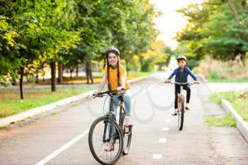 Cute children riding bicycles outdoors�