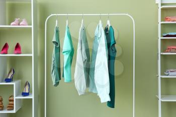 Rack with clean female clothes in dressing room�