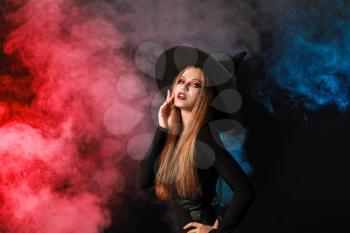 Beautiful woman dressed as witch for Halloween on dark background�