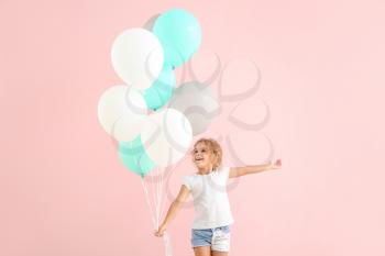 Little girl with balloons on color background�