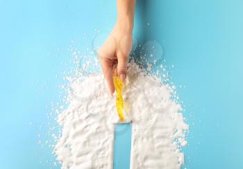Female hand with razor and shaving foam on color background�