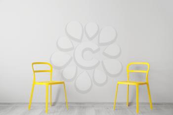 Stylish chairs near light wall�