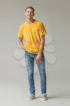 Young man in stylish t-shirt on grey background�
