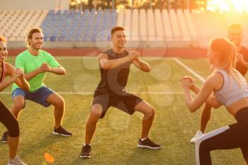 Group of sporty young people training at the stadium�