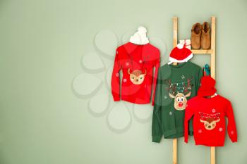 Set of family Christmas clothes on color background�