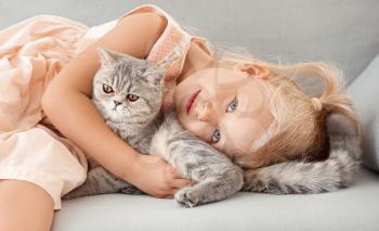 Little girl with cute cat at home�