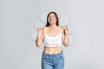 Young body positive woman on grey background�