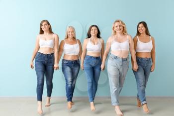 Group of body positive women near color wall�