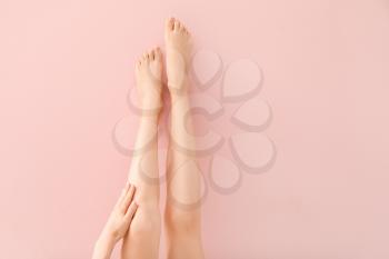 Beautiful female legs after depilation on color background�