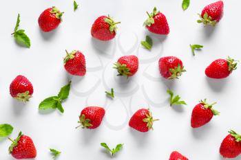 Many sweet ripe strawberries with mint on white background�