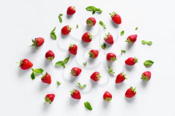 Many sweet ripe strawberries with mint on white background�