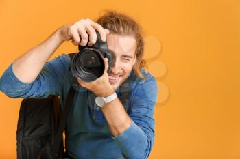 Young male photographer on color background�