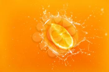 Falling of orange piece into juice, top view�