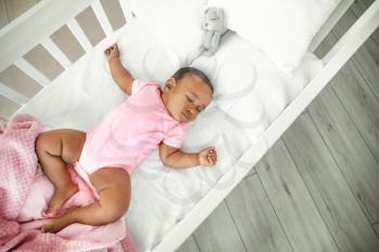 Little African-American baby sleeping in bed�