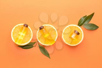 Composition with orange essential oil on color background�