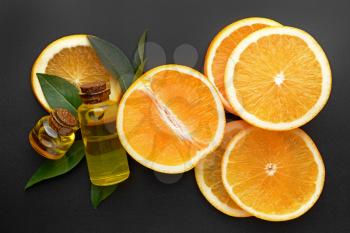 Composition with orange essential oil on dark background�