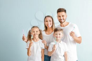 Portrait of family with toothbrushes on light background�