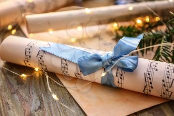 Christmas composition with music notes on wooden table�