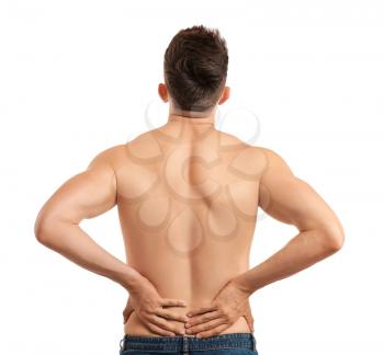 Young man suffering from back pain on white background�
