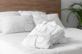 Soft clean bathrobes on bed�