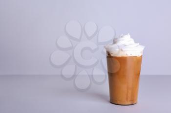 Cup of tasty frappe coffee on grey background�