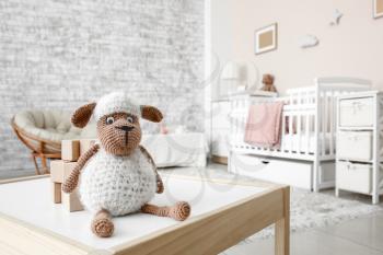 Wooden cubes with toy sheep on table in children's room�