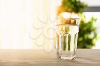 Glass of fresh water on table indoors�