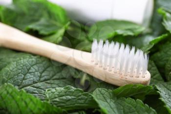 Wooden toothbrush on mint leaves�