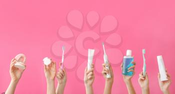 Female hands with toothbrushes, paste, mouth rinse, dental floss and model of jaw on color background�