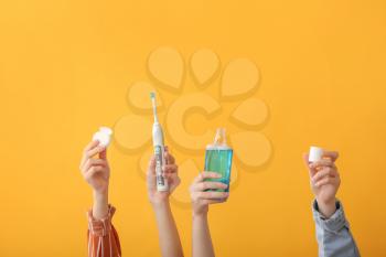 Female hands with toothbrush, mouth rinse and dental floss on color background�