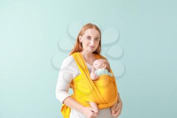Mother with cute baby on color background�