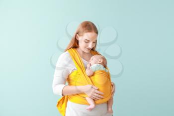 Mother with cute baby on color background 