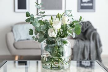 Vase with beautiful flowers on table in room�